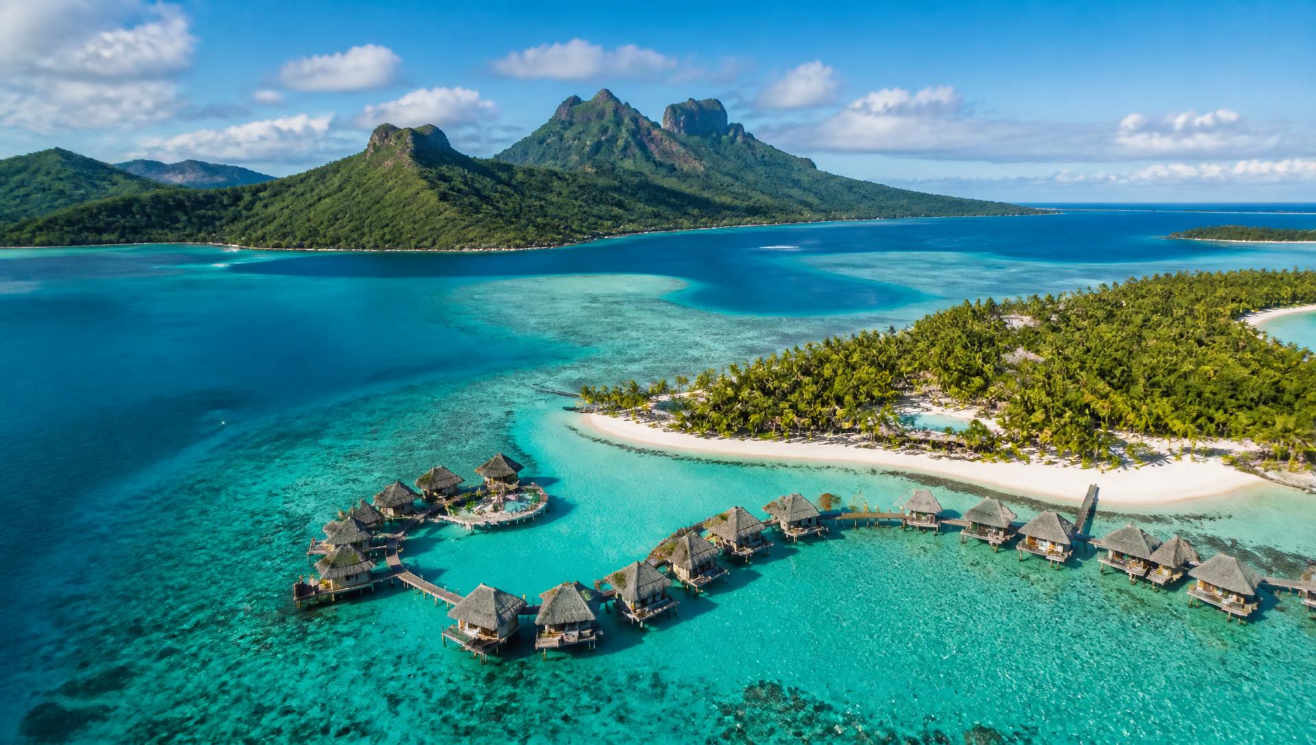 Aerial view of a turquoise tropical island lagoon with overwater bungalows